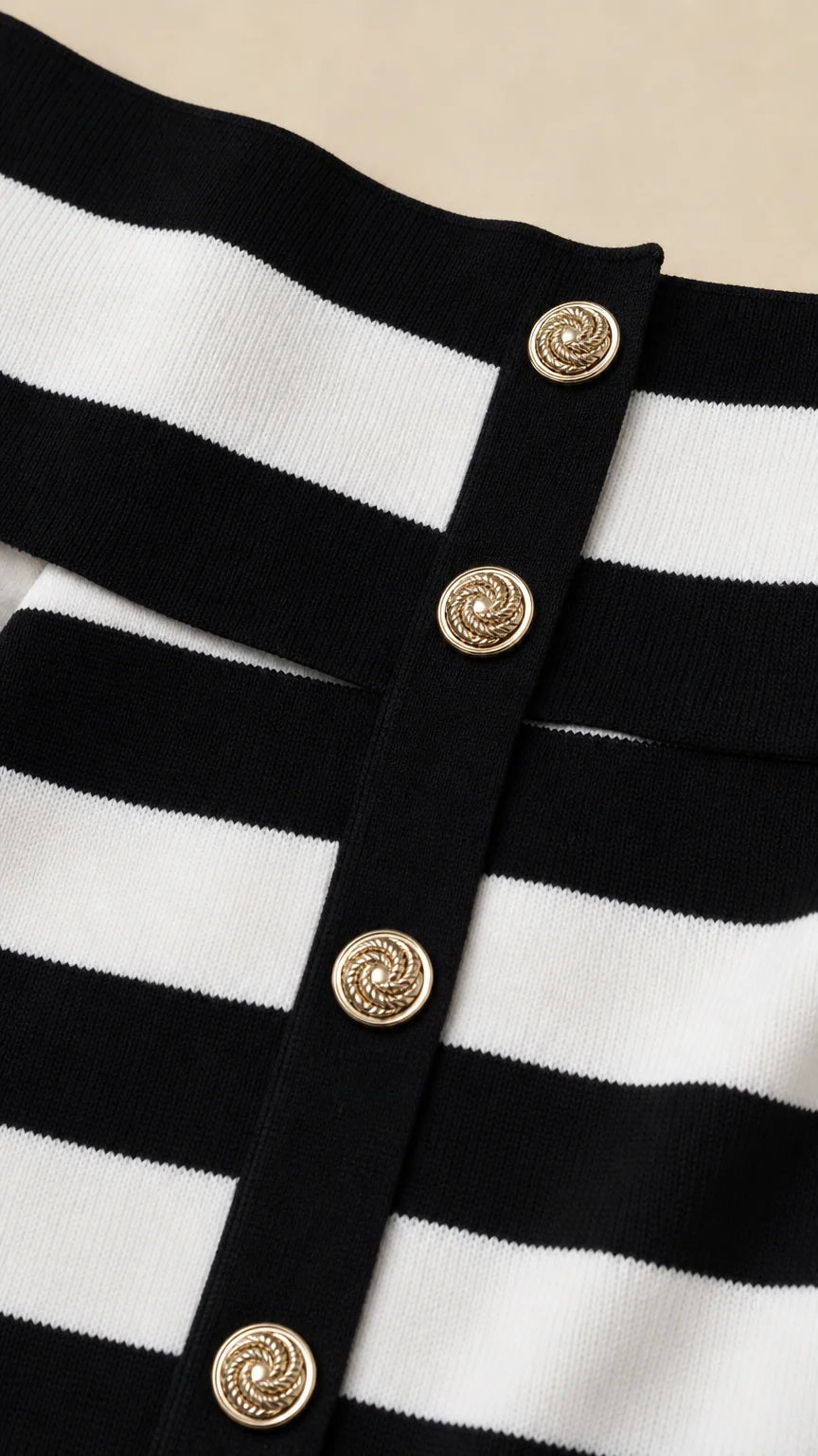 Close-up detail of gold-tone buttons on the striped knit dress