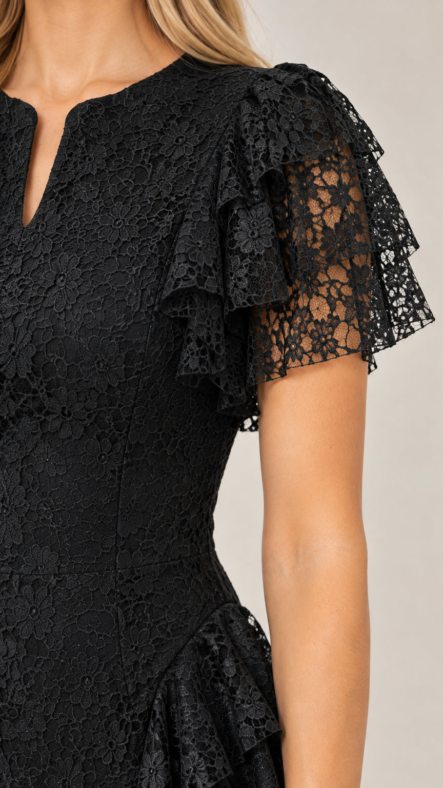 Close-up detail of Black lace bodice and tiered flutter sleeve