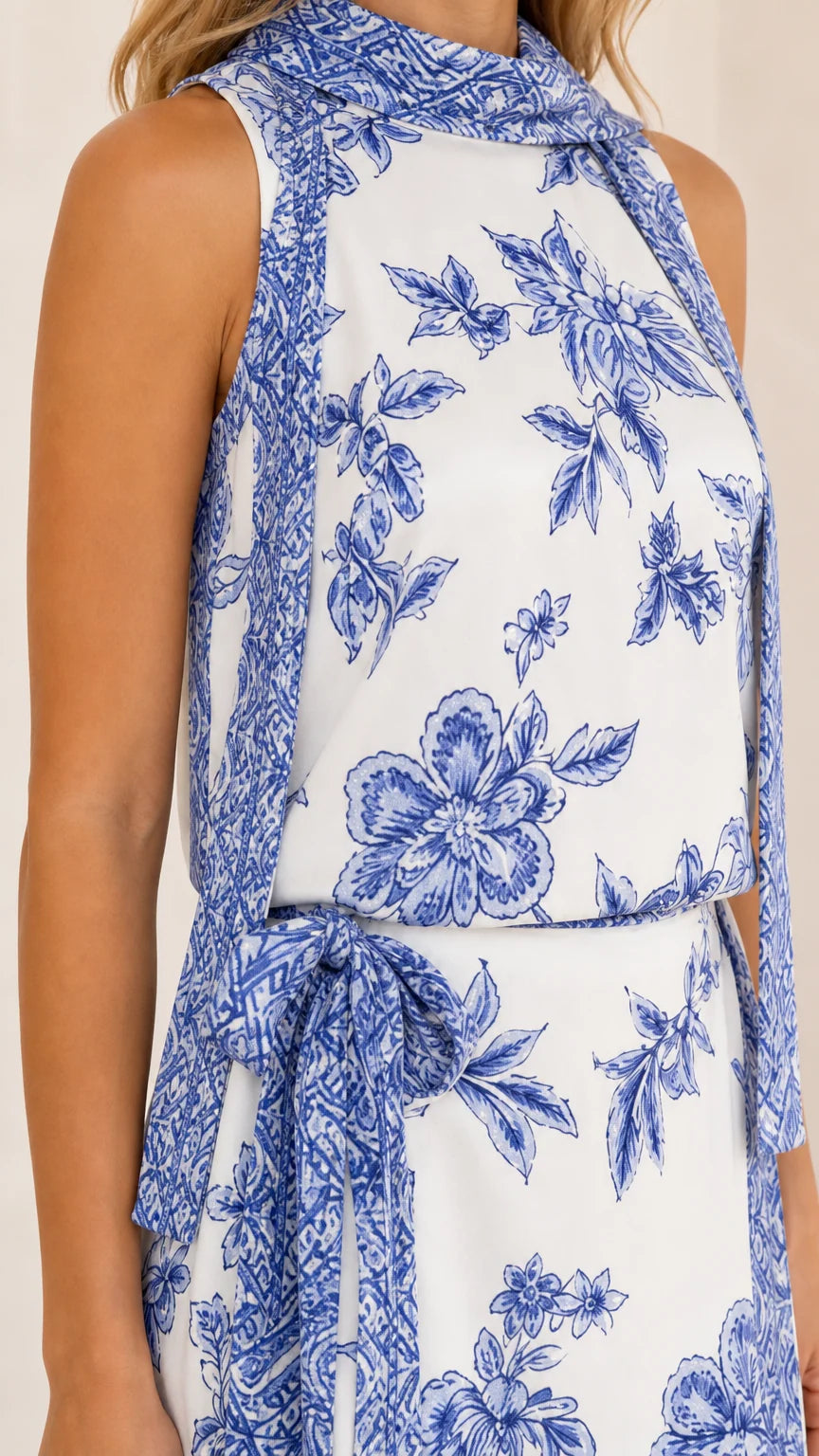Close-up of high neckline and floral print pattern on white dress