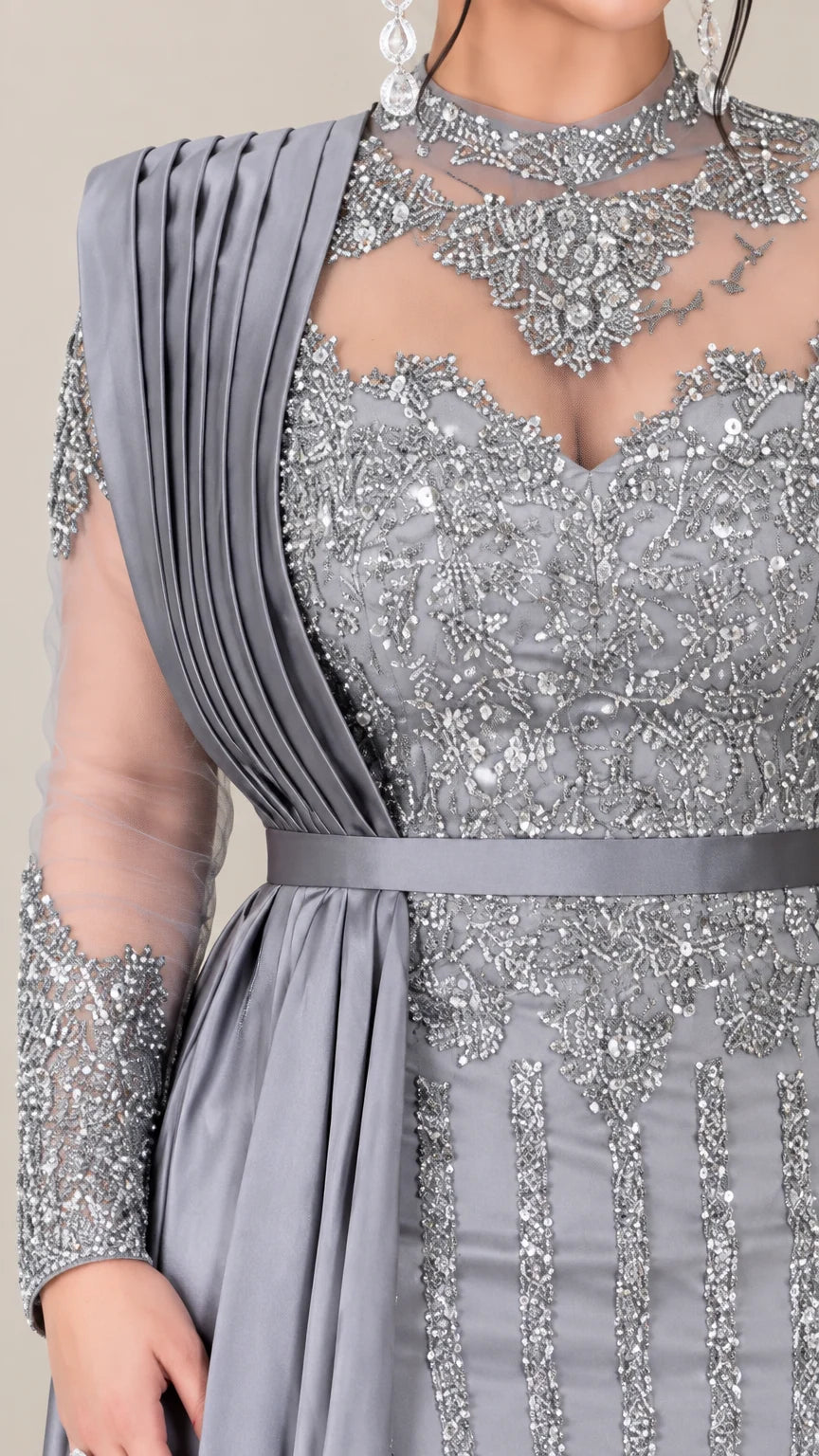 Close up of intricate beadwork and pleated shoulder drape on illusion neckline