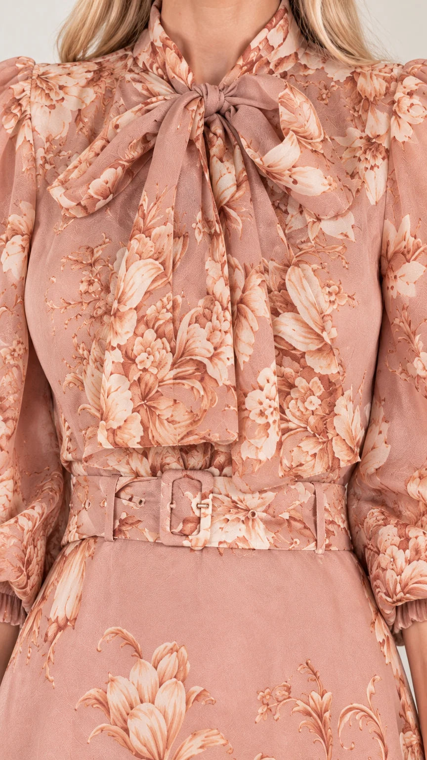 Close-up detail of bow tie neckline, floral pattern, and matching buckle belt on dusty rose dress