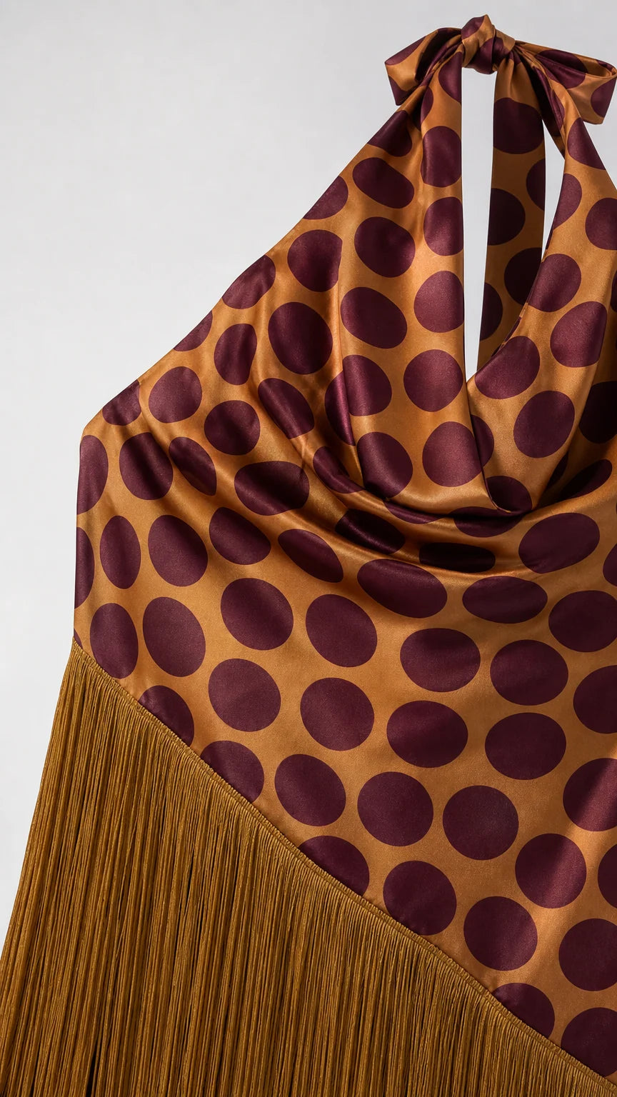 Close-up detail of halter neck tie, polka dot pattern, and fringe hem