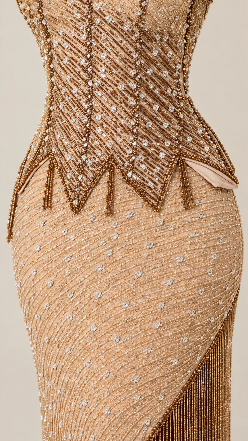 Close-up detail of geometric beadwork and pointed fringe trim at waist