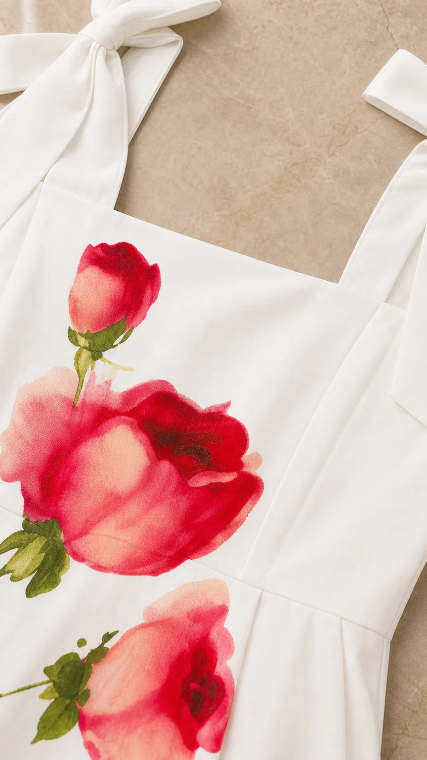 Close up of square neckline and red rose print on white fabric