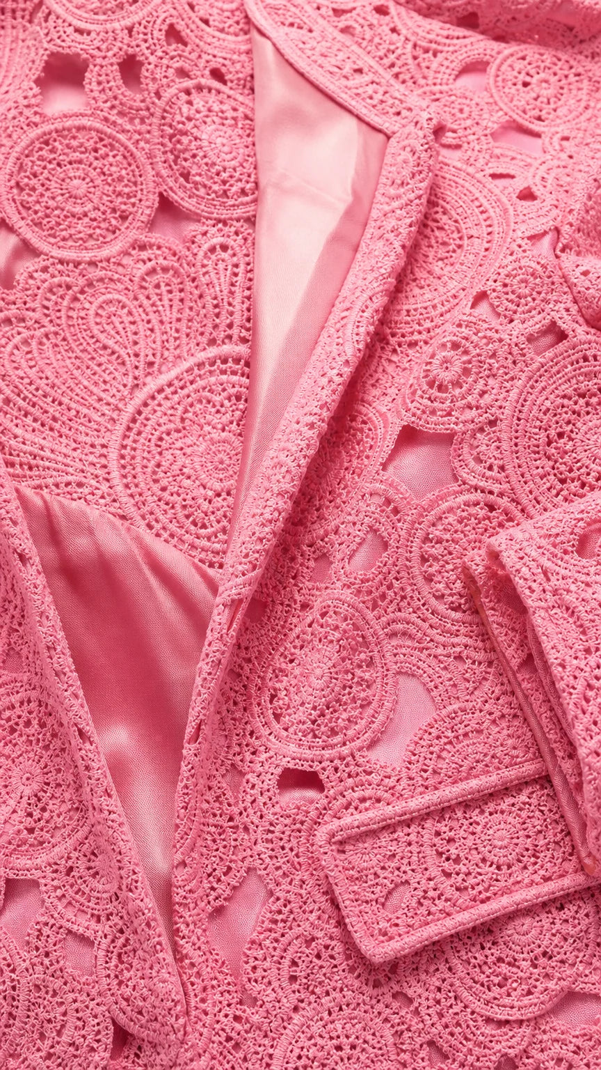 Close-up detail of pink textured lace fabric and satin lining