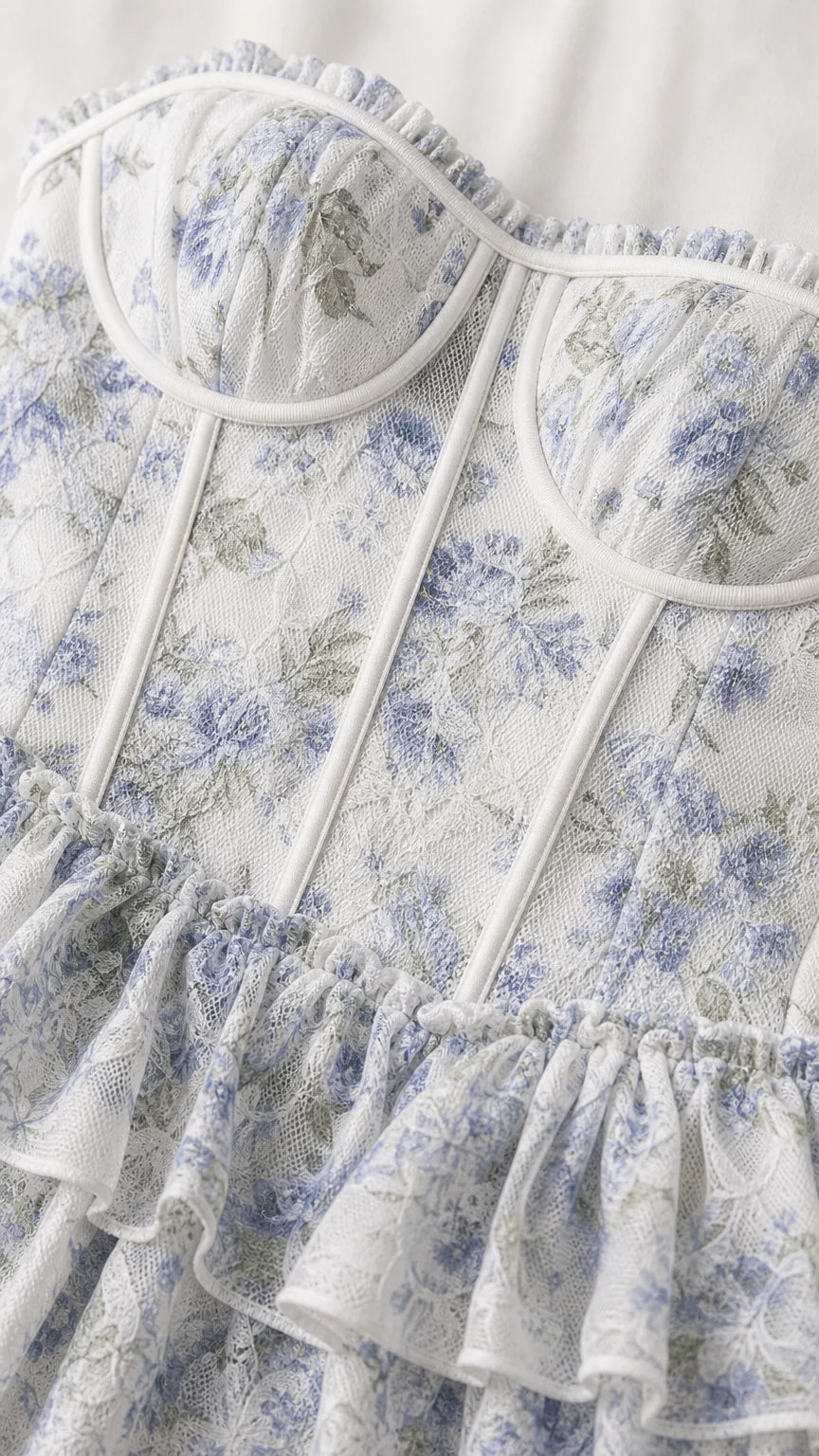 Close-up detail of white and blue floral bustier bodice with ruffles