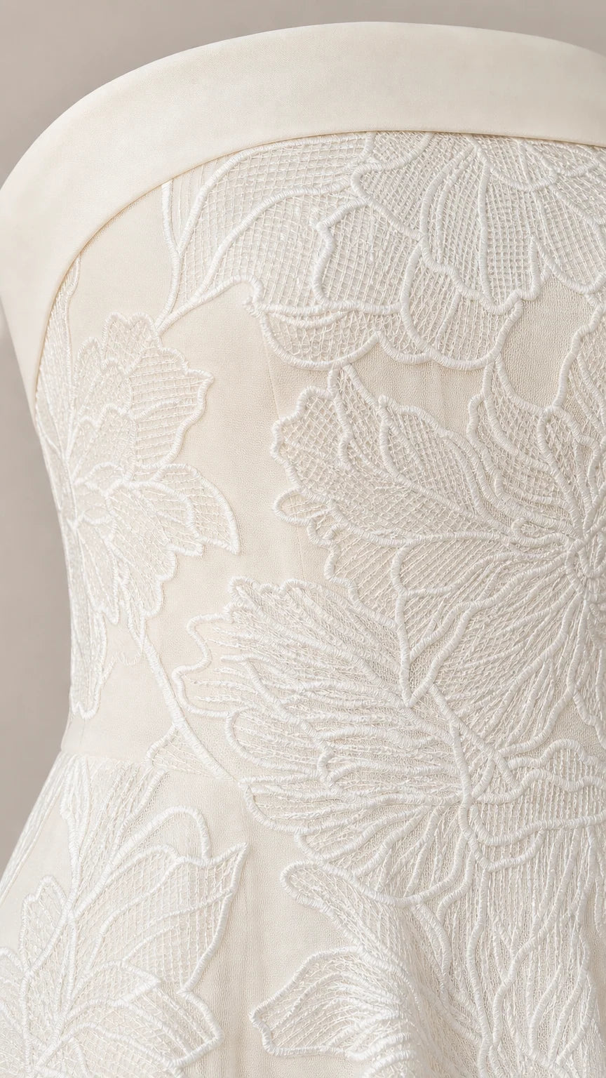 Close-up detail of white floral embroidery on strapless dress bodice