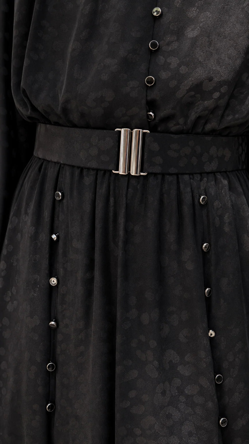 Close-up of black dress belt and button details