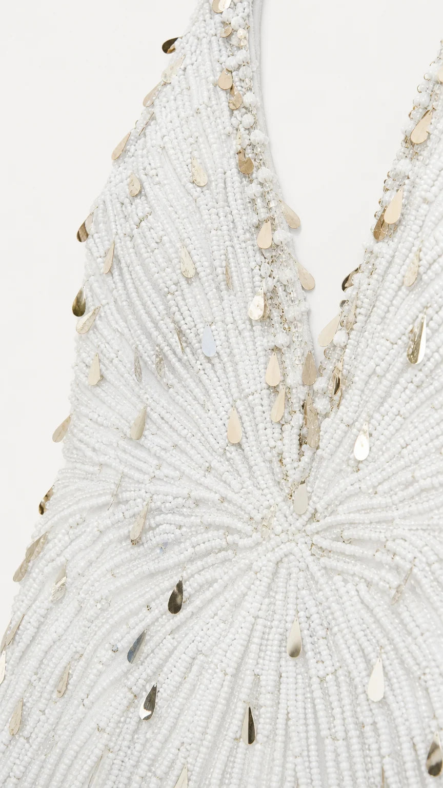 Close-up detail of intricate white seed bead and gold teardrop sequin embroidery