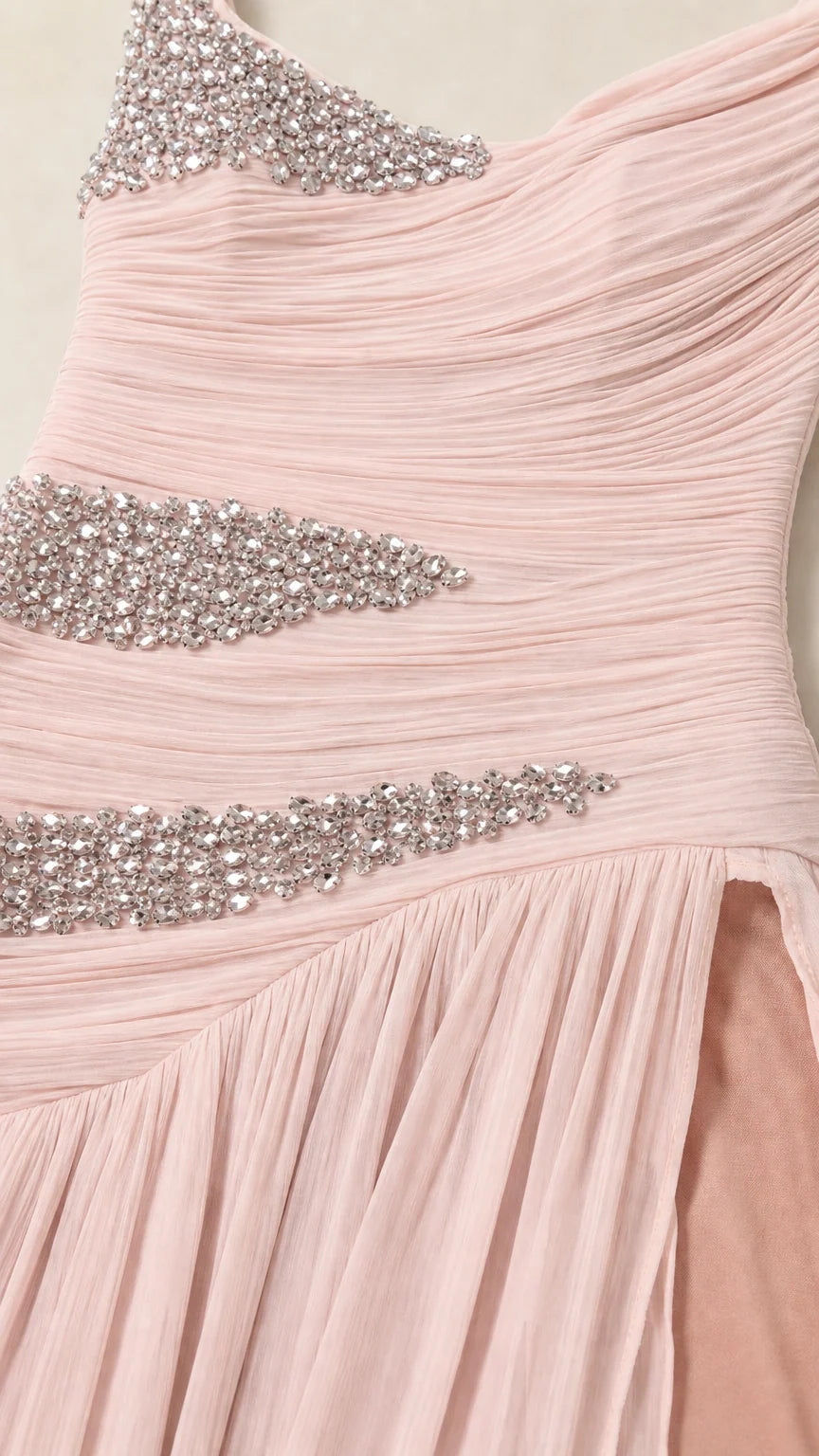 Close-up detail of delicate pink ruched chiffon fabric and sparkling rhinestone embellishments