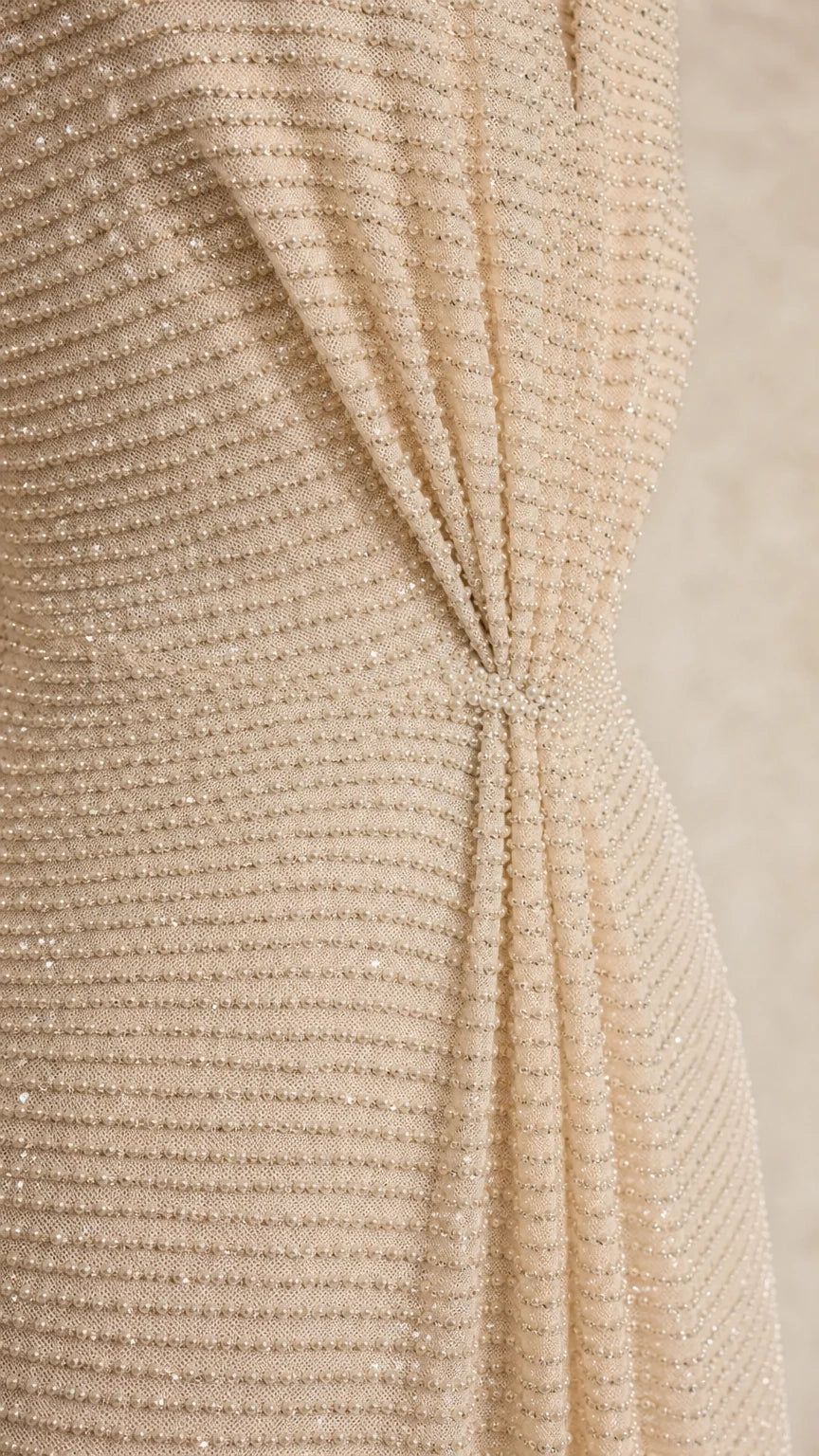 Close-up detail of textured fabric and front knot on champagne dress