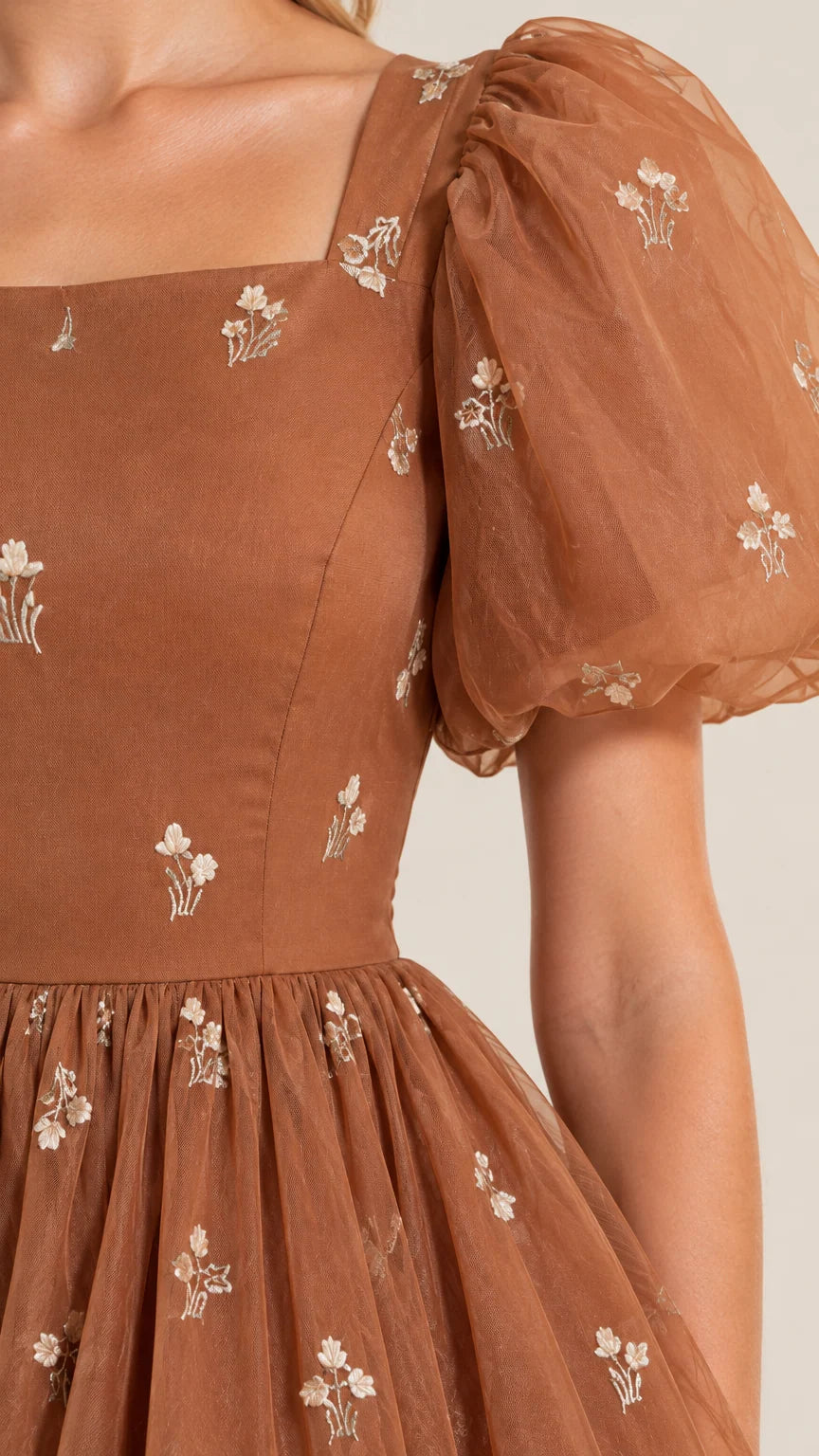 Close-up detail of sheer puff sleeve, square neckline, and floral embroidery on bodice