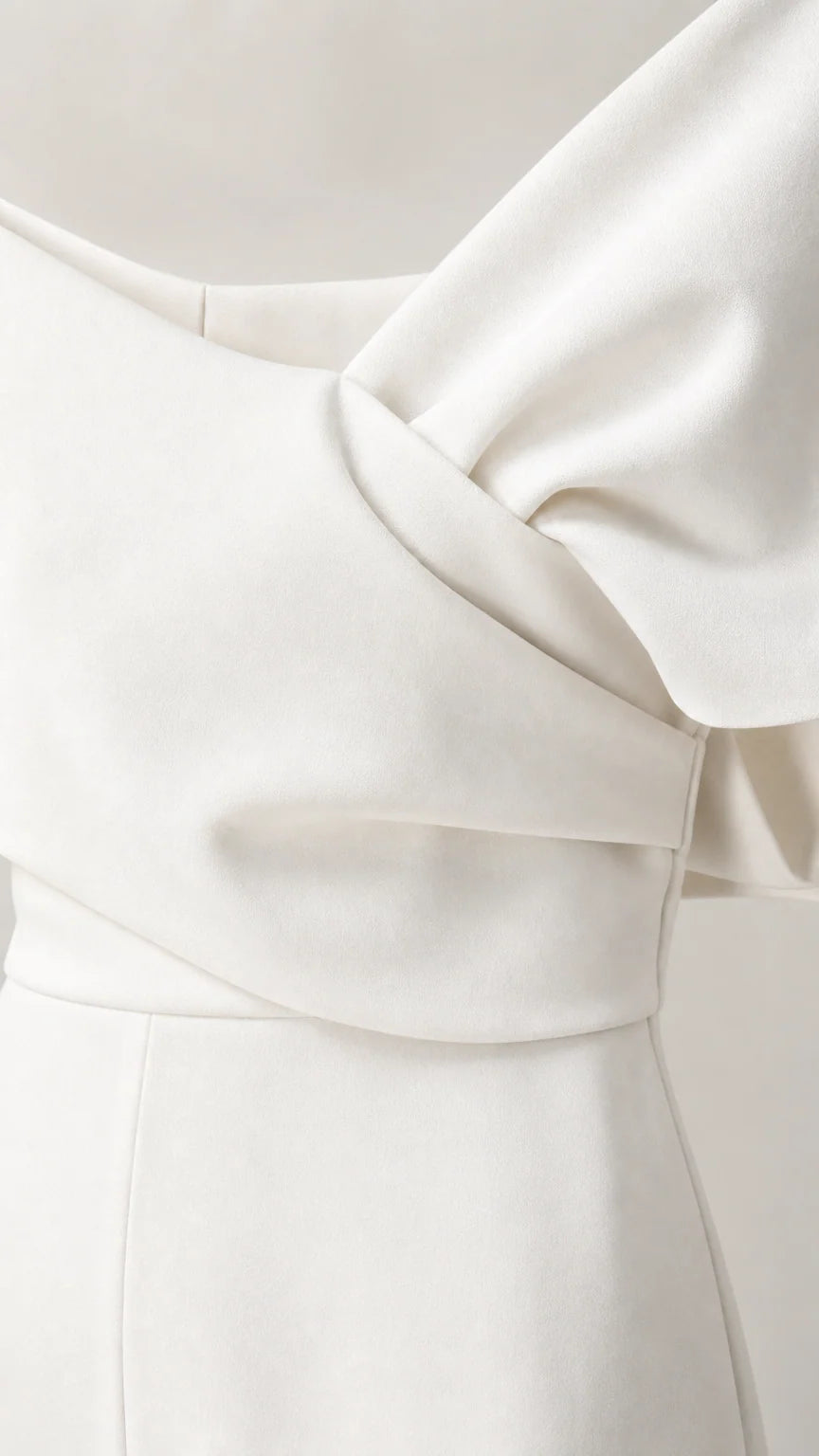 Close-up detail of draped bodice and fabric on white jumpsuit