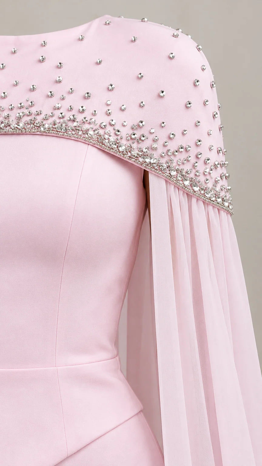 Close up detail of sparkling rhinestones on the shoulder and hem of the cape