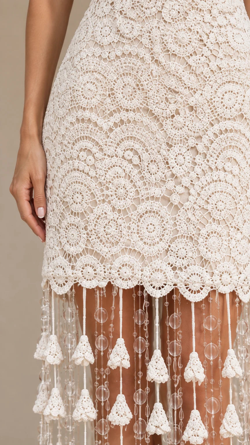 Close-up of intricate circular lace and tiered beaded tassel hem details