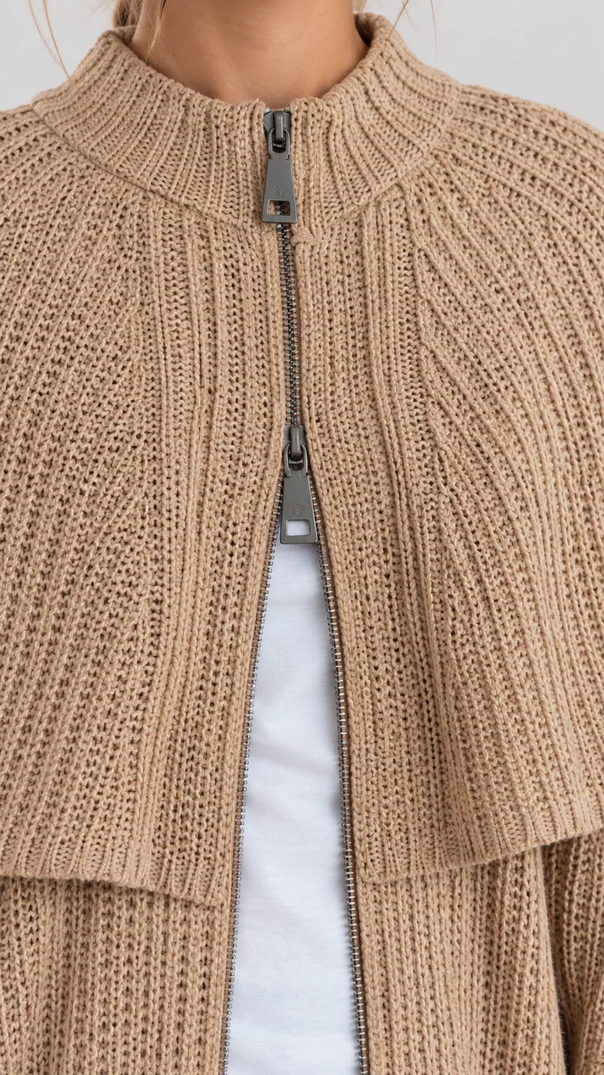 Close-up detail of mock neck ribbed knit and metallic zipper front closure