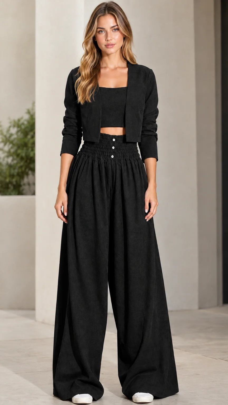 Front view of model wearing black 3-piece crop top, jacket, and wide-leg pants set