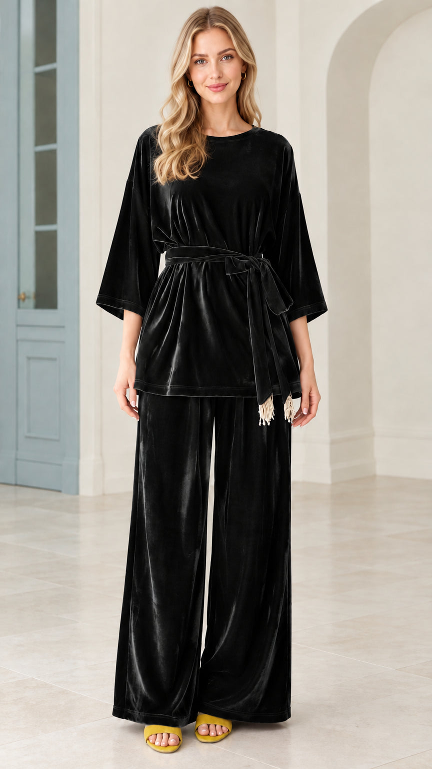 Model wearing black velvet belted top and wide leg pants matching set
