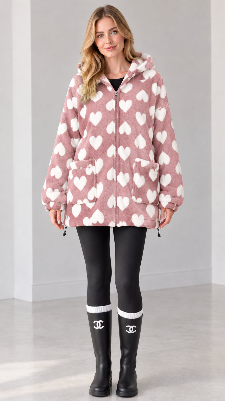Pink and white heart print hooded fleece zip-up jacket on model