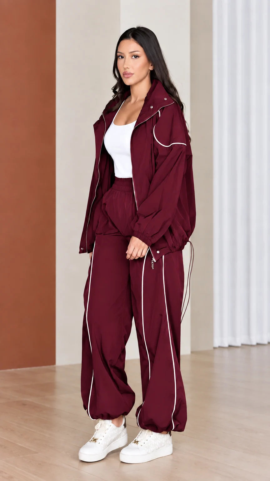 Full-length view of woman wearing rich burgundy red windbreaker tracksuit set