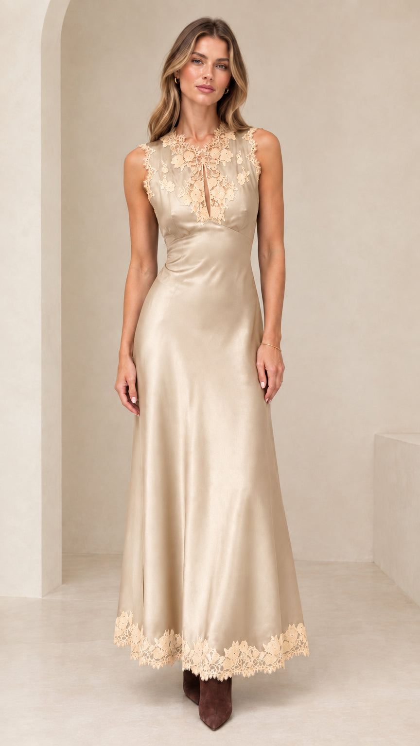 Model wearing champagne gold satin evening dress with lace neckline and hem